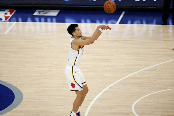 NBA篮球比赛现场，球员在三分线外投篮出手